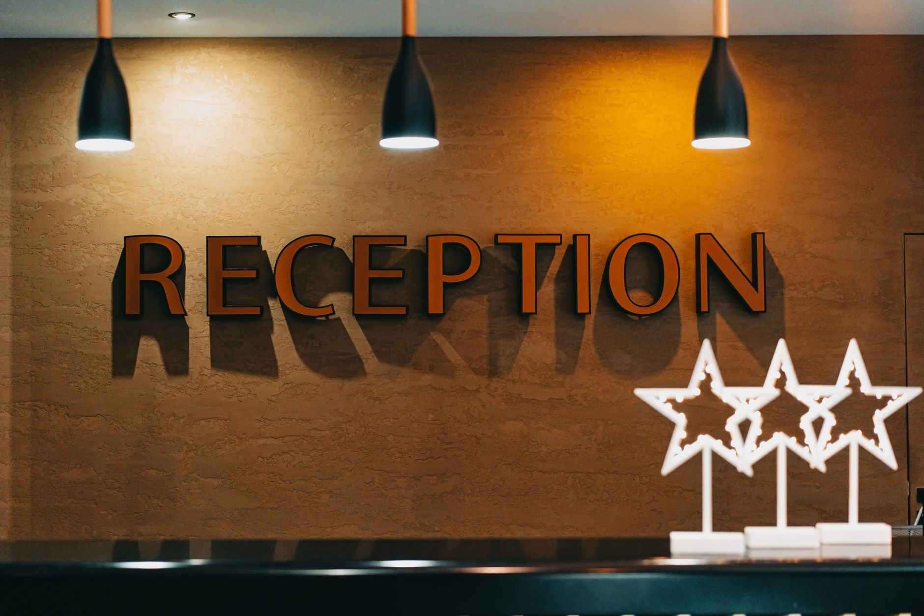 Hotel receptionist handing a key card to a guest at the front counter