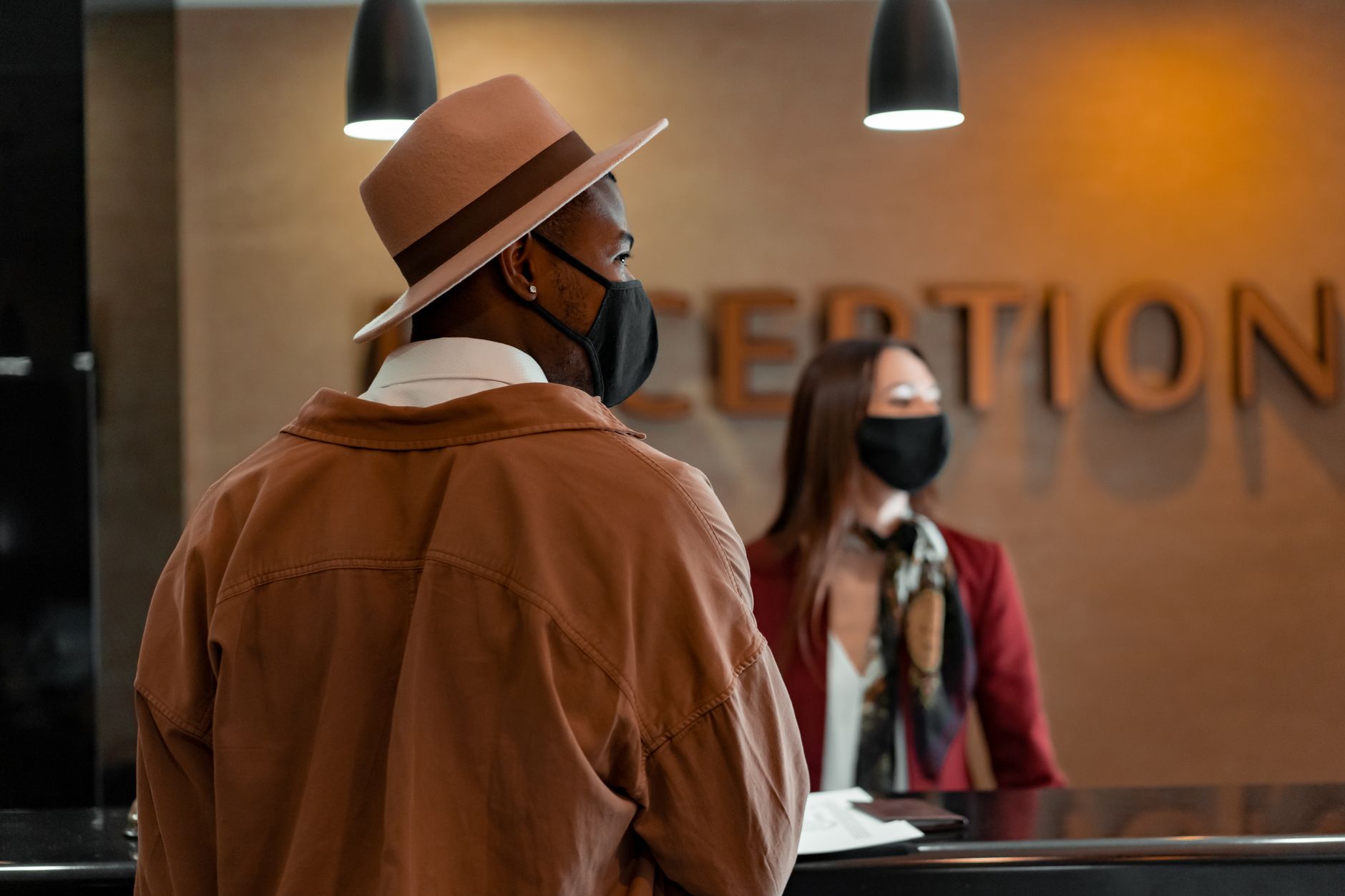 Receptionist and guest talking at a hotel front desk