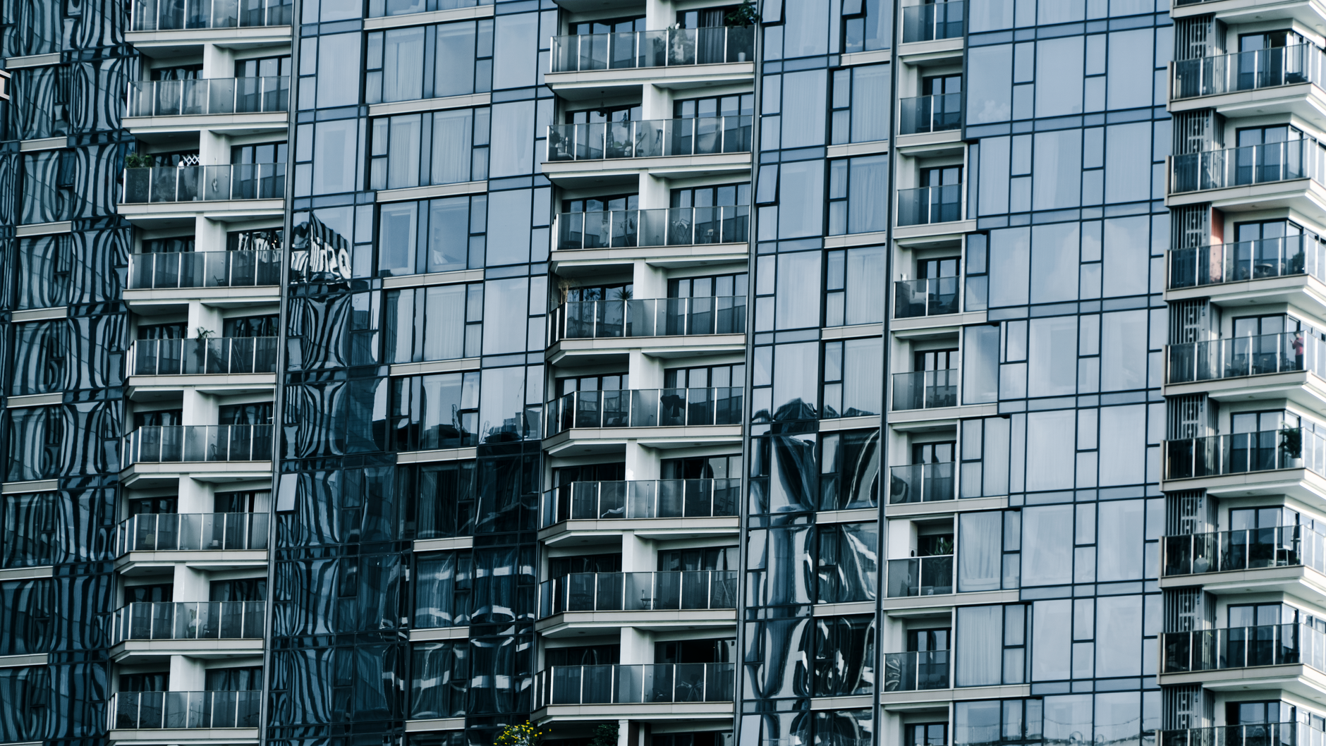 Agent showing a couple a condo balcony with a sea view
