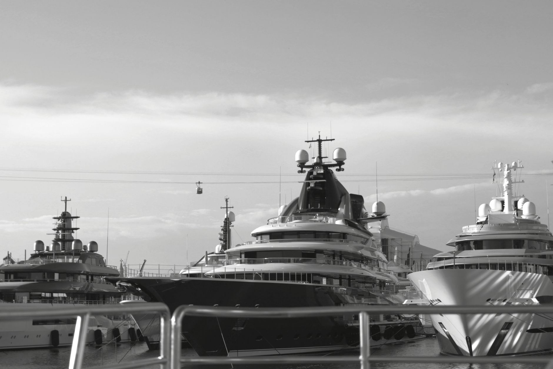 Crew member photographing a catamaran deck from a marina pontoon